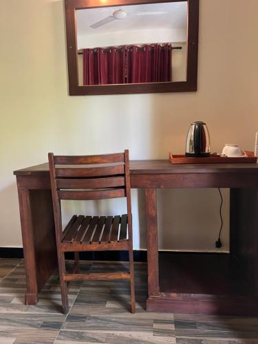 a wooden desk with a chair and a mirror at Green turtle in Tangalle