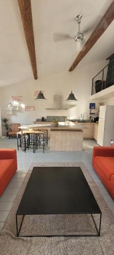 un salon avec une table et quelques chaises dans l'établissement Magnifique LOFT Déco sur le port et à 5mn des plages wifi Clim 85 m2, à La Ciotat