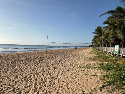 a sandy beach with palm trees and the ocean at Luxury penthouse , Nilaveli, Srilanka in Nilaveli