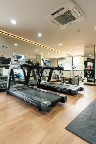 a gym with three treadmills in a room at Hotel IKON Phuket - SHA Extra Plus in Karon Beach