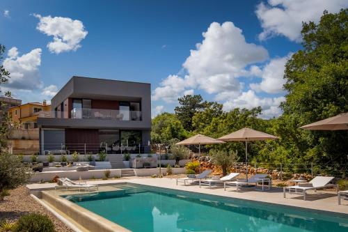 a villa with a swimming pool and a house at Luxusvilla Moana mit Olivenhain in Vrbnik
