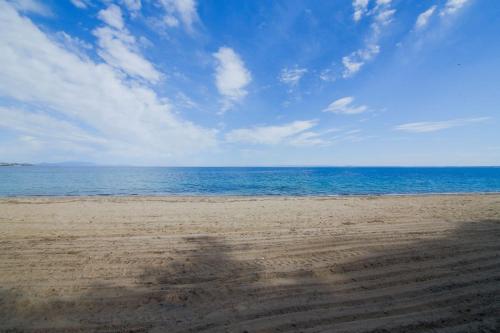 a shadow of a person on the beach at Falena Luxury Rooms in Kalyves Poligirou
