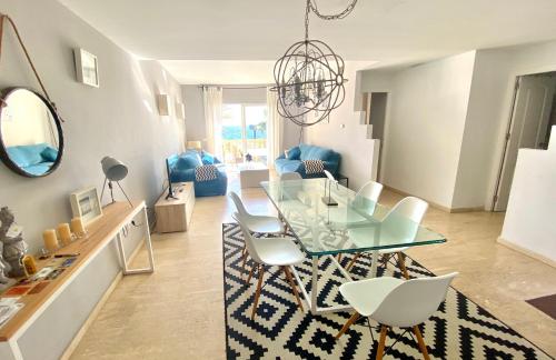 ein Esszimmer mit einem Glastisch und weißen Stühlen in der Unterkunft Sea frontline stylish beach House in Fuengirola
