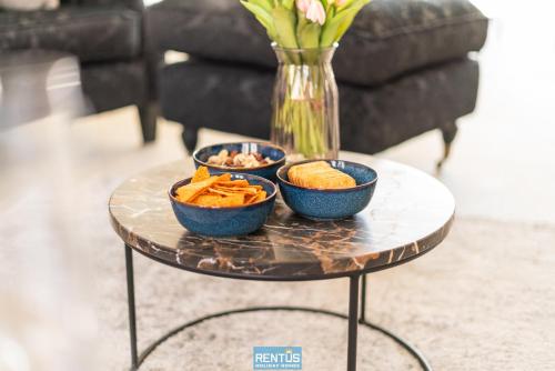 ein Tisch mit drei Schüsseln Cracker und einer Vase in der Unterkunft Villa Mater Maris - with large garden and garage in Middelkerke