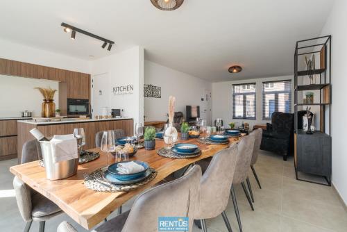 ein Esszimmer mit einem langen Holztisch und Stühlen in der Unterkunft Villa Mater Maris - with large garden and garage in Middelkerke
