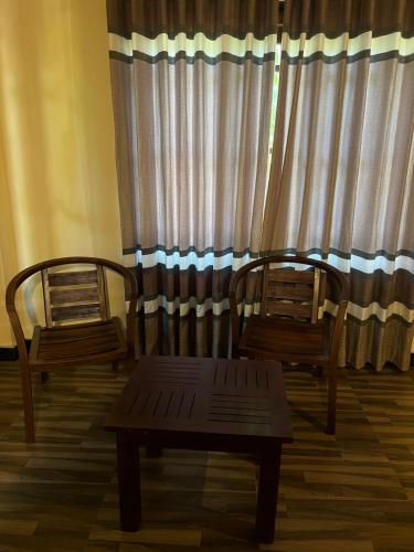two chairs and a table in front of a window at Green turtle in Tangalle