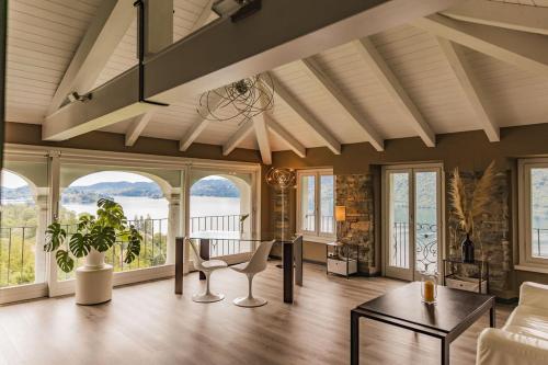 a living room with a table and some windows at Villa Antica Colonia SPA & Wellness in Pettenasco