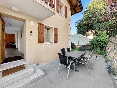 a patio with a table and chairs and an umbrella at The Rock House in Sion