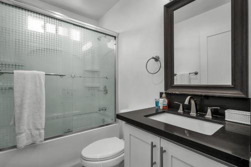 ein Badezimmer mit Toilette, Waschbecken und Spiegel in der Unterkunft Fully Furnished 1 Bedroom Apartment with Full Bathroom in Koreatown Free Gated Parking Full Kitchen in Los Angeles