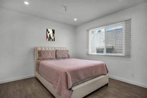 ein weißes Schlafzimmer mit einem Bett und einem Fenster in der Unterkunft Fully Furnished 1 Bedroom Apartment with Full Bathroom in Koreatown Free Gated Parking Full Kitchen in Los Angeles