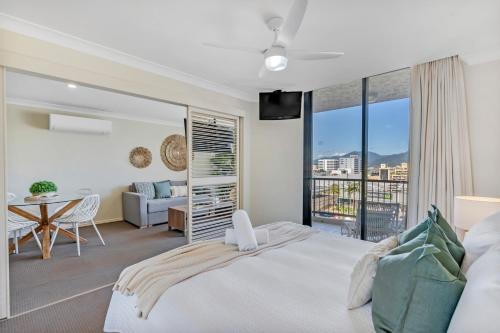 a bedroom with a large bed and a balcony at Esplanade Escape in Cairns