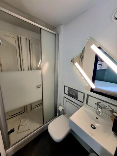 a bathroom with a white toilet and a sink at ibis budget Marne La Vallée Noisy Le Grand in Noisy-le-Grand