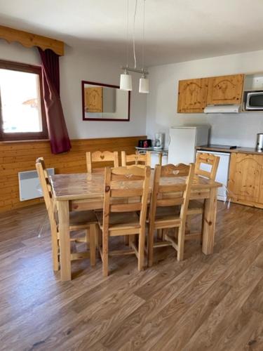 a dining room with a wooden table and chairs at Sunny Slopes Les Balcons de Recoin 6 pers in Chamrousse