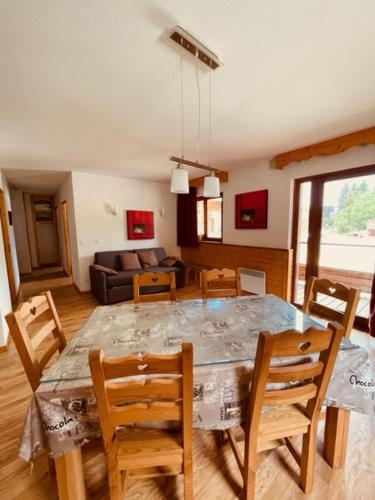 une salle à manger et un salon avec une table et des chaises dans l'établissement Sunny Slopes Les Balcons de Recoin 6 pers, à Chamrousse