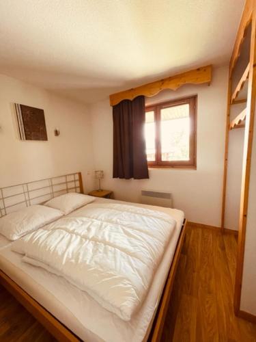 une chambre avec un lit blanc et une fenêtre dans l'établissement Sunny Slopes Les Balcons de Recoin 6 pers, à Chamrousse