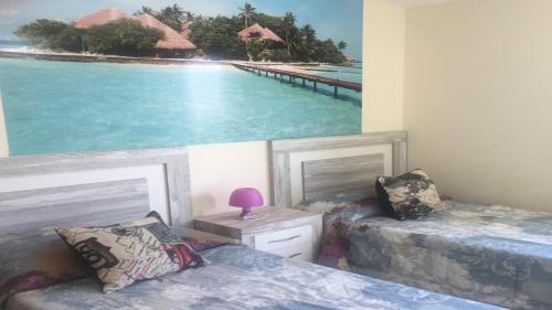 sypialnia z 2 łóżkami i zdjęciem plaży w obiekcie Fabuloso alojamiento compuesto por 4 chalets adosados de lujo en Panorámica Golf para 28 personas piscina con CIRCUITO SPA w mieście San Jorge