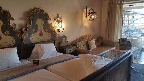 a hotel room with two beds and a couch at Alp Art Hotel Götzens in Innsbruck