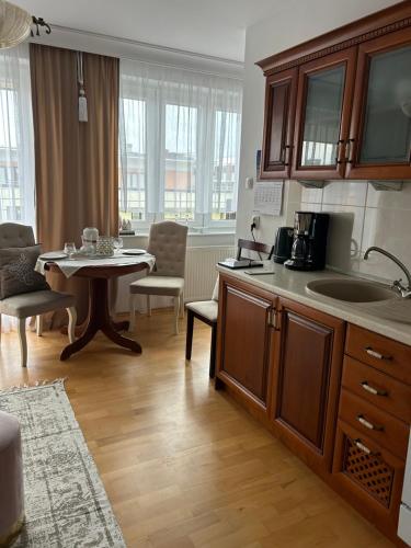 una cucina con un tavolo e una sala da pranzo di Opera Palace I LUX RELAX Apartamenty Kołobrzeg a Kołobrzeg
