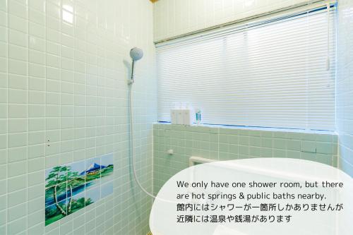 a bathroom with a toilet with a sign on it at 1166 Backpackers in Nagano
