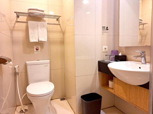 a small bathroom with a toilet and a sink at Swiss-Belinn Manyar in Surabaya