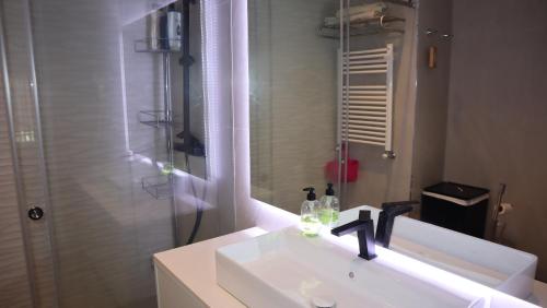 a white bathroom with a sink and a shower at Pool and sea view accommodation 50 m sea in Furadouro