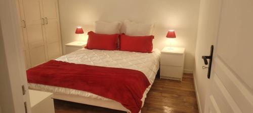 - une petite chambre avec un lit et des oreillers rouges dans l'établissement Marais - Place des Vosges, à Paris