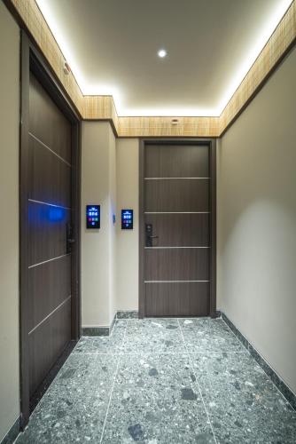 an empty corridor with two doors in a building at TK Phu Quoc Hotel - Grand World Phu Quoc in Phu Quoc