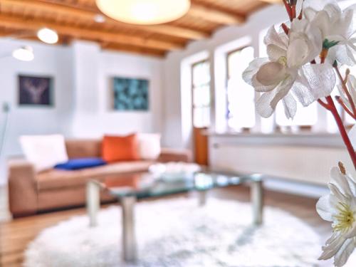 ein Wohnzimmer mit einer Couch und einem Glastisch in der Unterkunft Ferien im Fachwerkhaus mit Heimkino & Sauna & Pools in Burgwedel