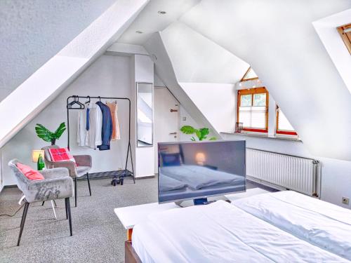 a attic bedroom with a bed and a tv at Ferien im Fachwerkhaus mit Heimkino & Fitnessraum & Pools in Burgwedel