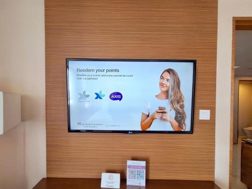 a flat screen tv hanging on a wall at Swiss-Belinn Manyar in Surabaya