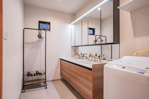 a bathroom with a sink and a washing machine at Apartment Hotel 11 Villa Tengachaya in Osaka