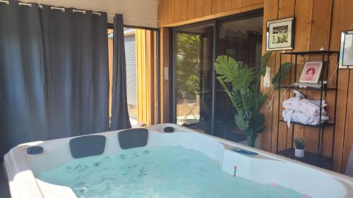 une baignoire dans une pièce avec une fenêtre dans l'établissement NiD'Amour Gîte La Colombe, à Bézenac