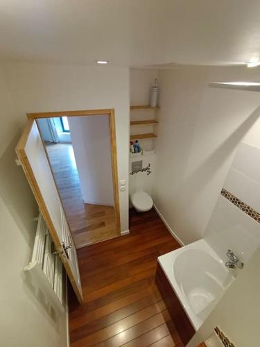 La salle de bains blanche est pourvue de toilettes et d'un escalier. dans l'établissement Maison de village climatisée tout confort, à Grisolles