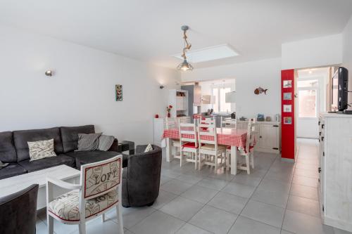 un salon et une cuisine avec un canapé et une table dans l'établissement Maison de vacances familiale, à Les Sables-dʼOlonne