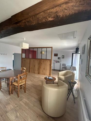 une salle à manger et un salon avec une table et des chaises dans l'établissement Au Numéro 4, à Épertully