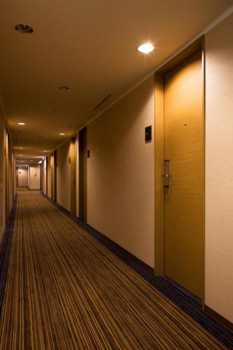 an empty corridor in a building with a yellow door at the b hakata in Fukuoka