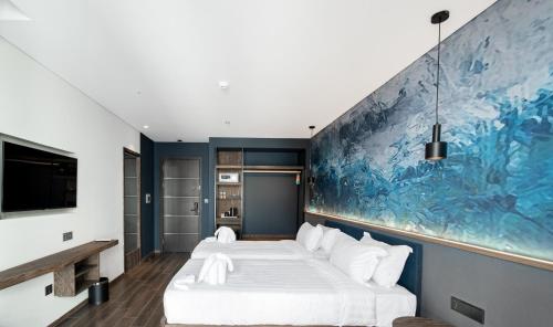 a bedroom with a large blue painting on the wall at TK Phu Quoc Hotel - Grand World Phu Quoc in Phu Quoc