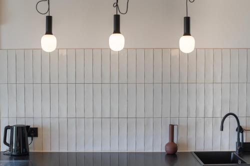 a kitchen with three lights above a sink at Osada Przystanek Czorsztyn in Czorsztyn
