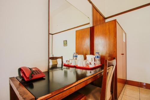 a desk with a telephone and cups and a phone at Hotel Bumi Asih Gedung Sate Bandung in Bandung