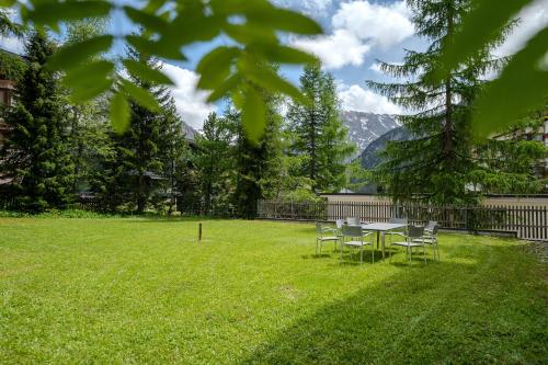 a picnic table and chairs in a grassy yard at Haus Padrun 2 in Arosa