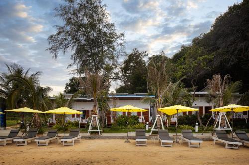 a group of chairs and yellow umbrellas at One Beach Resort By EHM in Koh Rong Sanloem