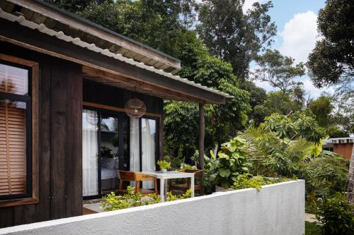 a wooden house with a white table in a garden at One Beach Resort By EHM in Koh Rong Sanloem