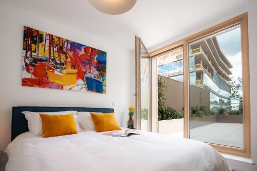 a bedroom with a bed and a large window at Media Bay Apartments in Kirchberg by Rentaroo in Luxembourg