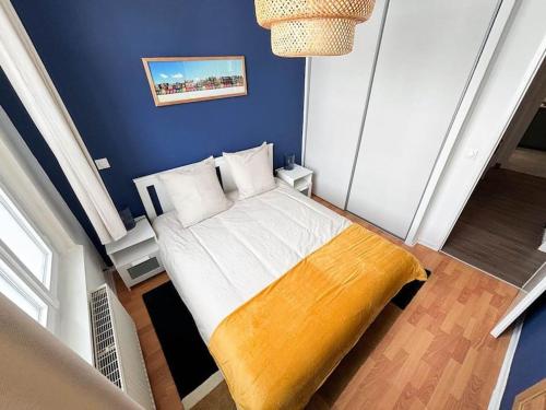 una camera da letto con un letto in una parete blu di Le Turenne à 400 m de la plage a Dunkerque