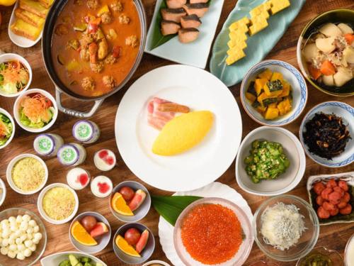 a table topped with bowls of different types of food at Shin Furano Prince Hotel in Furano