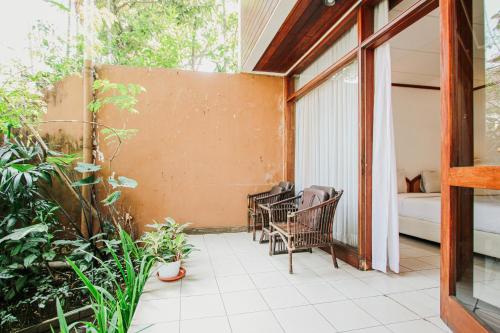 a patio with chairs and plants on a balcony at Hotel Bumi Asih Gedung Sate Bandung in Bandung