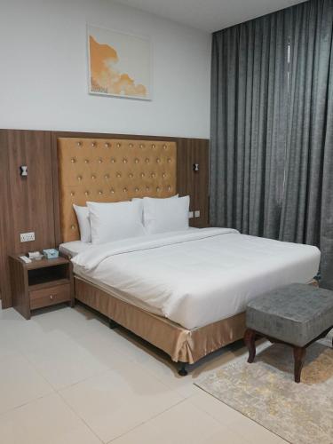 a bedroom with a large bed with a wooden headboard at Dream Point Hotel in Fujairah