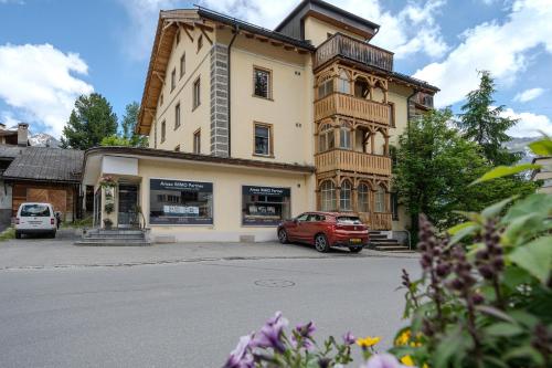 a red car parked in front of a building at Haus Padrun 5 in Arosa