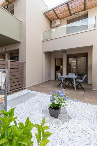 eine Hausterrasse mit einem Tisch und Blumen in der Unterkunft SithoniaRS Seashell Maisonette in Nikiti