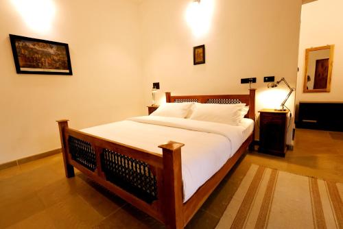 a bedroom with a large bed with white sheets at The Hidden Pearl Palakkad by Chakolas Hospitality in Thenkurissi